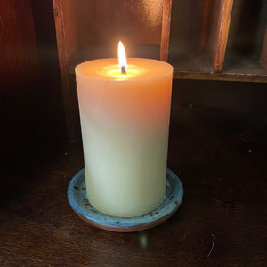 Beeswax candle lit on our hand thrown ceramic candle plate