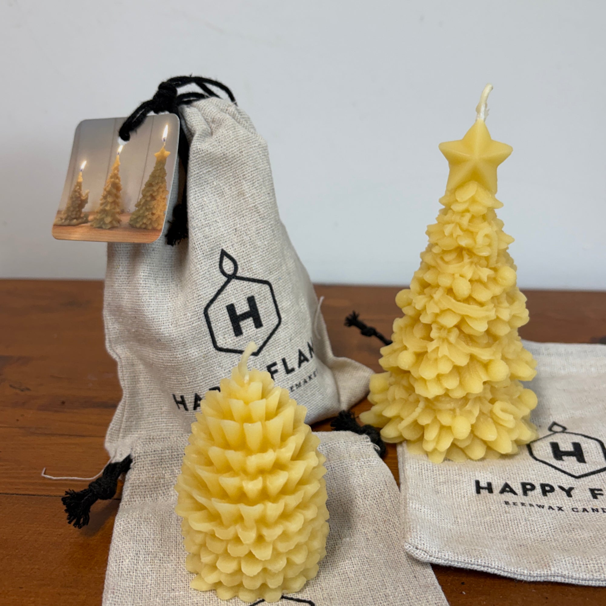 Two Beeswax Christmas tree candles with a beeswax pine cone candle