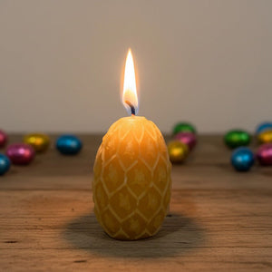 Beeswax Easter egg candle with chocolate Easter eggs in the background