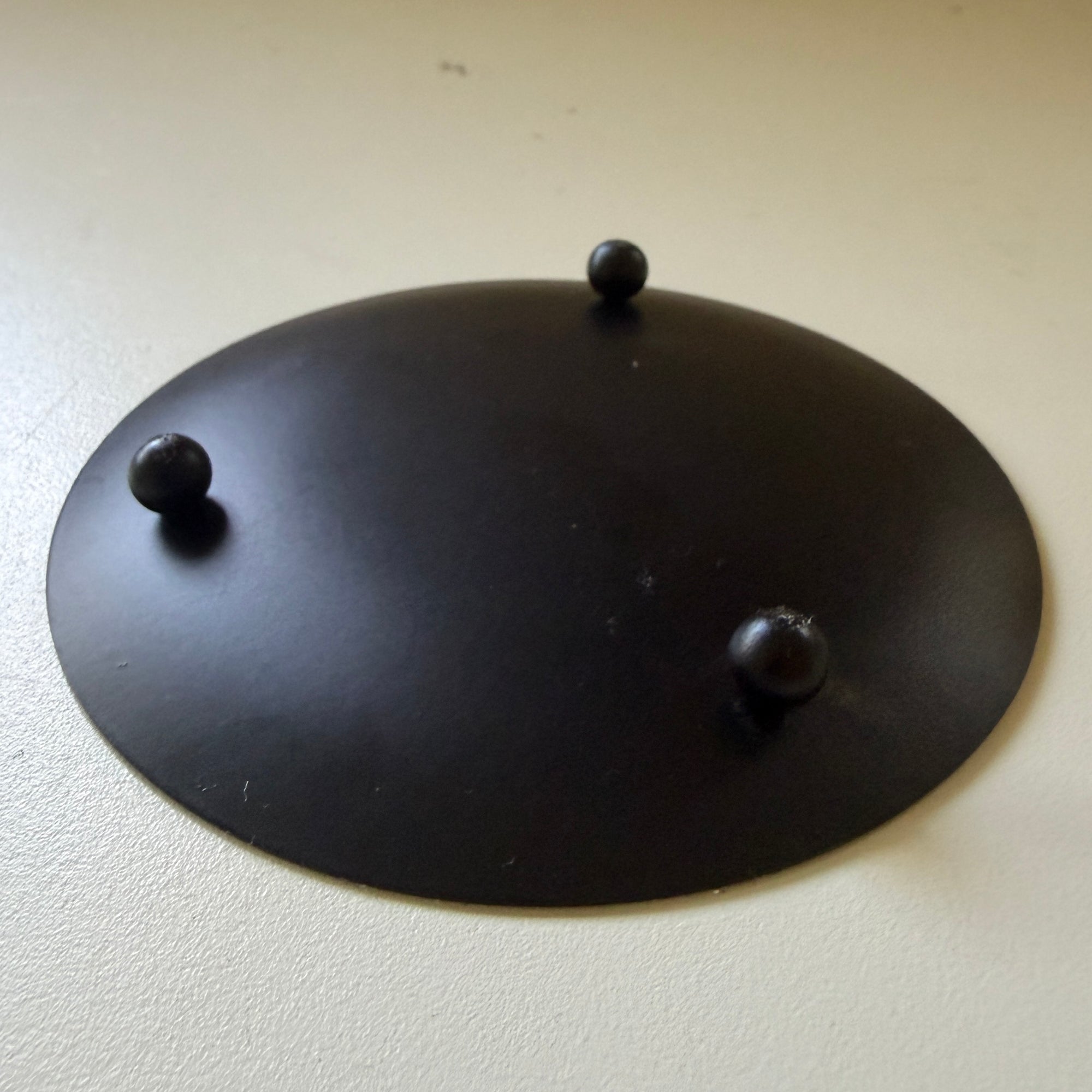 Round black metal candle plate with feet