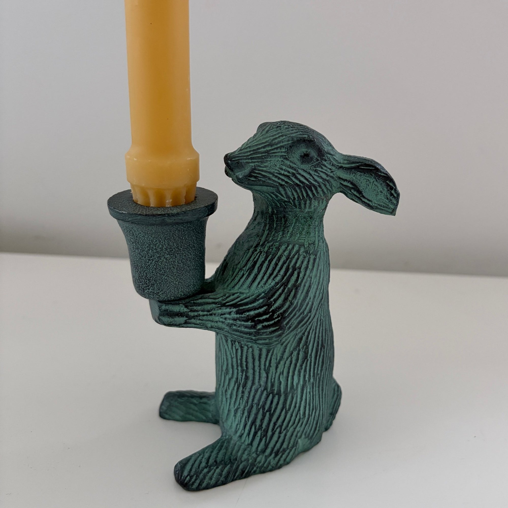 Metal rabbit shaped candle holders with Antique finish holding a candle 2- Happy Flame