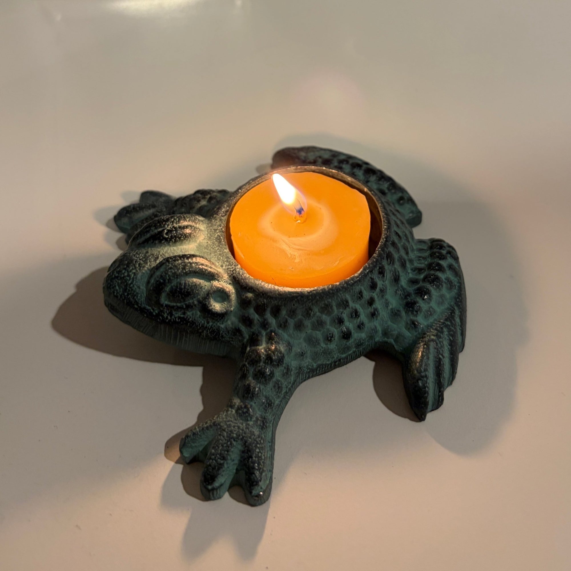Metal frog shaped candle holders with Antique finish holding a candle- Happy Flame