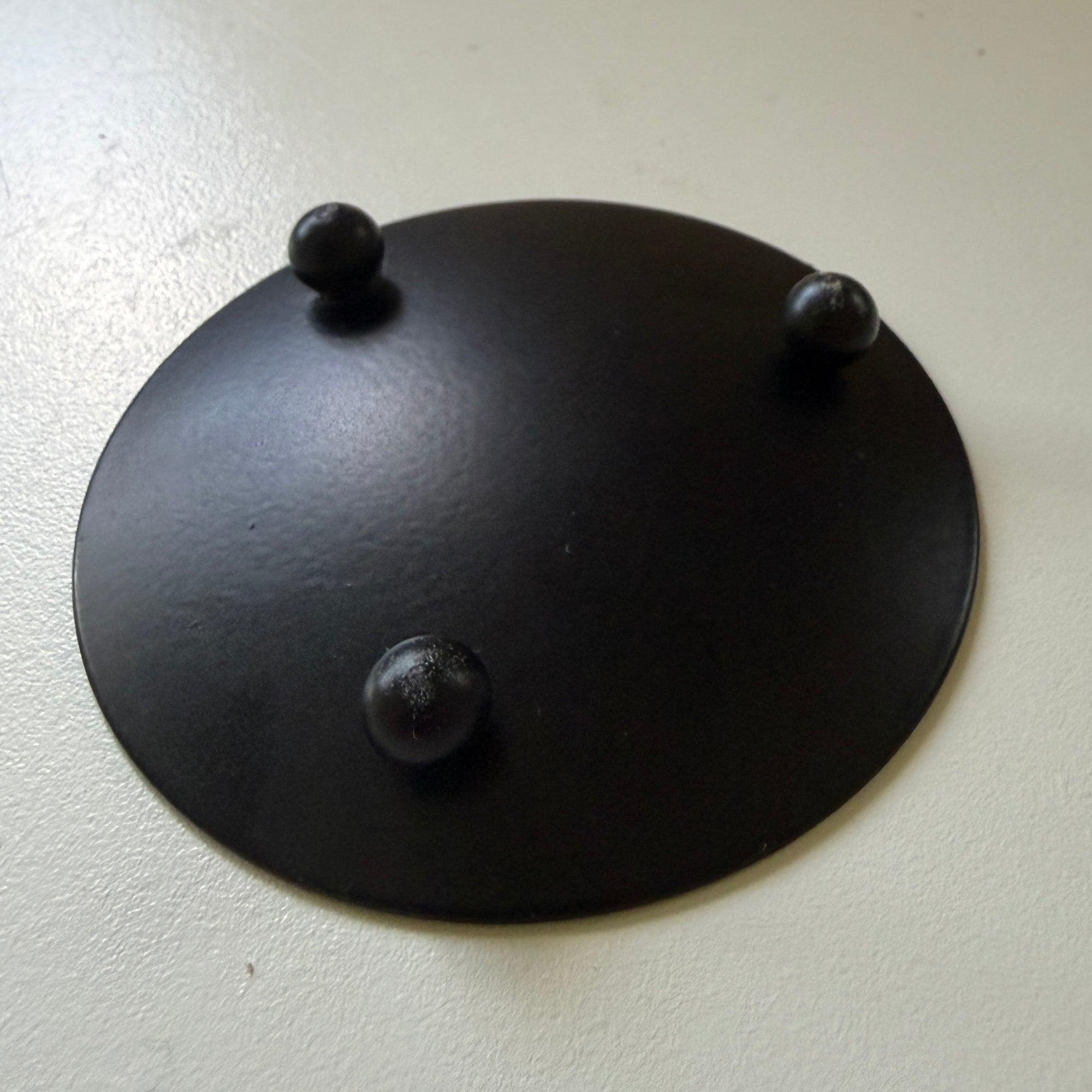 Round black metal candle plate with feet